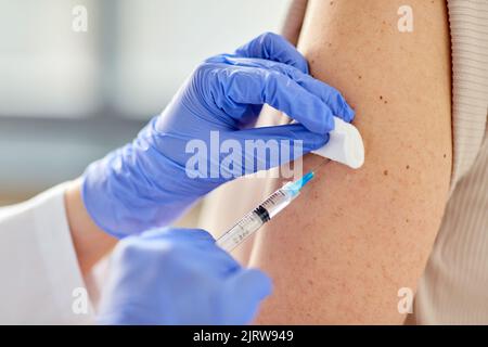 Nahaufnahme der Hand mit Spritze, die den Patienten impft Stockfoto