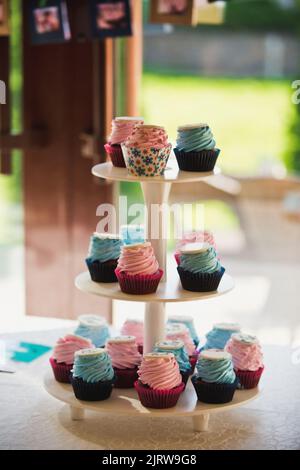 Muffins mit rosa Creme und Schilder auf einem Tablett Stockfoto