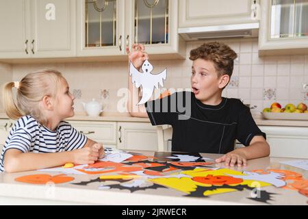 Kinder bereiten Dekorationen für die Halloween-Feiertage vor, basteln Kunsthandwerk. Stockfoto