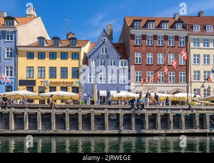 Entspannen in der Sonne am beliebten Touristenziel Nyhavn ein Kanal mit bunten 17. C Häuser Cafés und Bars gesäumt - Kopenhagen Dänemark Stockfoto