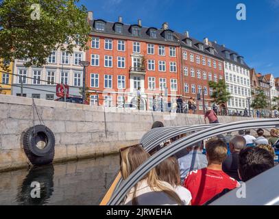 Touristen genießen eine geführte Tour durch Kopenhagen Dänemark auf einem Kanalboot, das bei strahlendem Sonnenschein entlang des Frederiksholms Kanal segelt Stockfoto