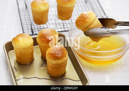 Herstellung von Rum baba ( baba au Rhum ), traditionelles französisches und italienisches Dessert Stockfoto