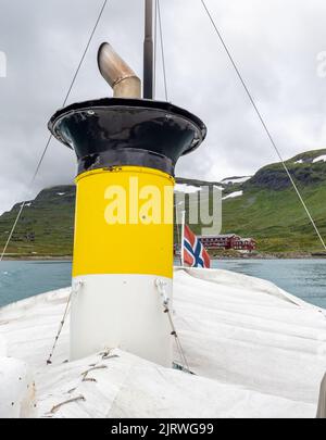 Die Fähre Bitihorn mit ihrem leuchtend gelben Trichter fährt von Eidsbugarden nach Bygdin auf dem See Bygdin im Jotunheimen Nationalpark Norwegen Stockfoto