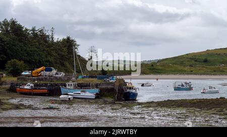 Clonakilty, Irland, 2. Juli 2022. Ein alter Anlegesteg und mehrere festfahrene Fischerboote in der Clonakilty Bay. Fischerboote ankerten bei Ebbe. Flaches Meer, l Stockfoto