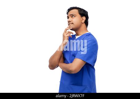 Denkender indischer männlicher Arzt in blauen Peelings Stockfoto
