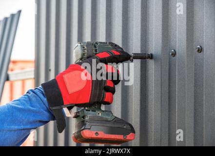 Der Master arbeitet als Schraubenschlüssel mit einem profilierten Blech. Stockfoto