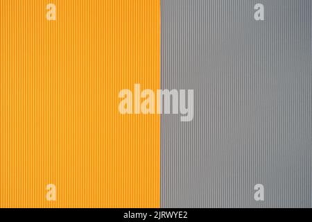 Grauer und orangefarbener zweifarbiger Papierhintergrund mit Streifen. Abstrakter Hintergrund moderne Hipster futuristisch. Strukturdesign Stockfoto