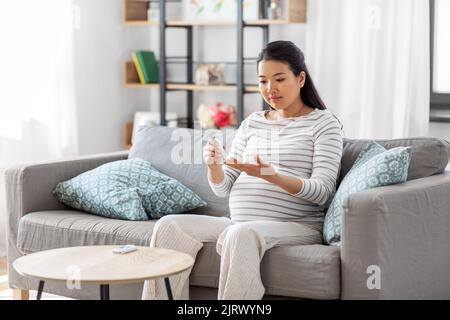 Schwanger Frau mit Glukosimeter macht Bluttest Stockfoto