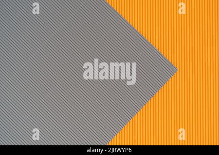 Grauer und orangefarbener zweifarbiger Papierhintergrund mit Streifen. Abstrakter Hintergrund moderne Hipster futuristisch. Strukturdesign Stockfoto