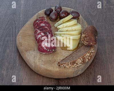 Traditionelle hausgemachte istrische Salami-Wurst mit Käse Oliven und braunem Brot auf Holztablett Stock Foto Stockfoto