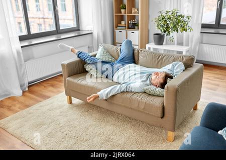 Junger Mann schläft zu Hause auf dem Sofa Stockfoto