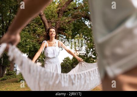 Glückliches Paar, das Picknickdecke im Sommerpark legt Stockfoto