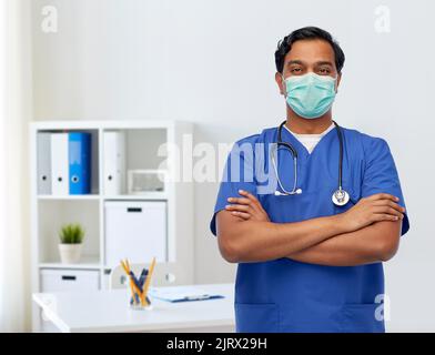 indischer Arzt in blauer Uniform und Maske Stockfoto