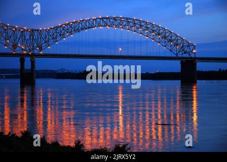 Die Lichter der DeSoto Bridge, die die I-40 zwischen Memphis Tennessee und Arkansas transportiert, spiegeln sich im ruhigen Wasser des Mississippi River wider Stockfoto