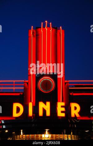 Ein Vintage-Diner im Retro-Stil wird nachts mit Neonlichtern beleuchtet Stockfoto