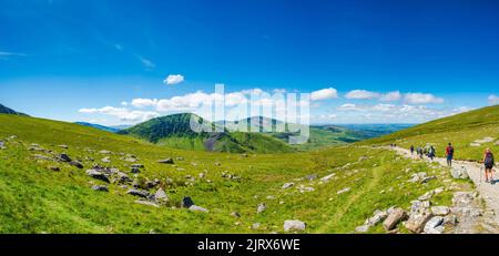 SNOWDON, WALES - 09. JULI 2022: Wanderer gehen vom Mount Snowdon nach Erreichen des Gipfels hinunter. Snowdon ist der höchste Berg in Wales, an einem Höhenhang Stockfoto