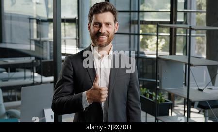 Bärtig glücklich zuversichtlich bärtig kaukasisch 40s Mann mittleren Alters Chef Führer Händler Verkäufer Geschäftsmann kreative Firma CEO zeigt Daumen nach oben gute Idee Stockfoto