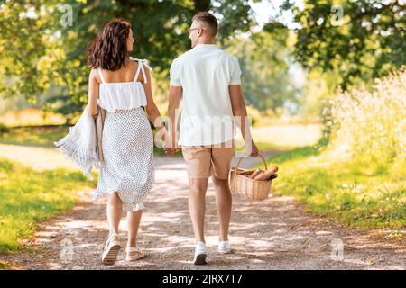 Glückliches Paar mit Picknickkorb im Sommerpark Stockfoto