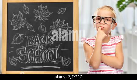 Kleine Studentin Mädchen in Brille denken Stockfoto