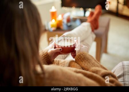 Frau schaut an halloween Fernsehen und trinkt Kakao Stockfoto