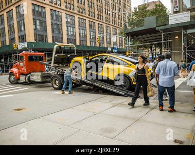 Ein Abschleppwagen bereitet sich darauf vor, am Sonntag, den 21. August 2022, ein behindertes Ford Mustang Mach-E EV-Taxi in Chelsea in New York zu entfernen. Im Juli lieferte Ford 4.970 EV Mustangs aus, die den benzinbetriebenen Mustang übertrafen. (© Richard B. Levine) Stockfoto