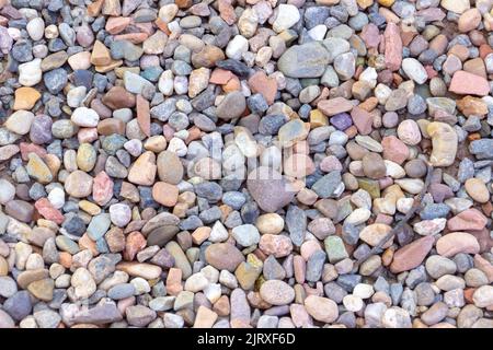 Textur von farbigen Steinen mit einem Stück Zweig in Rio de Janeiro Brasilien. Stockfoto