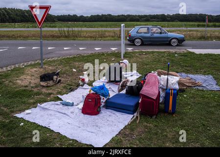 Ter Apel, Niederlande. 26. August 2022. 2022-08-26 18:09:37 TER APEL - Asylsuchende warten vor dem Tor am überfüllten Antragszentrum in Ter Apel. In den letzten Nächten haben 700 Personen außerhalb des Anwendungscenters geschlafen, weil nicht genügend Platz vorhanden ist. Die Regierung macht Eile, um dem Chaos ein Ende zu setzen. ANP VINCENT JANNINK netherlands Out - belgium Out Credit: ANP/Alamy Live News Stockfoto