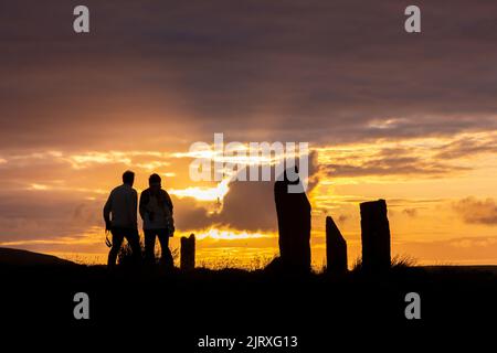 Orkney, Großbritannien. 26. August 2022. Besucher genießen den Sonnenuntergang am Ring of Brodgar, Orkney. Die 5.000 Jahre alten massiven Steine sind Teil des neolithischen Orkney-Weltkulturerbes. Kredit: Peter Lopeman/Alamy Live Nachrichten Stockfoto