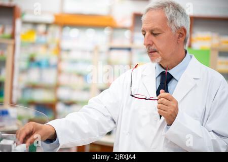 Apotheker auf der Suche nach einem Medikament im Regal Stockfoto