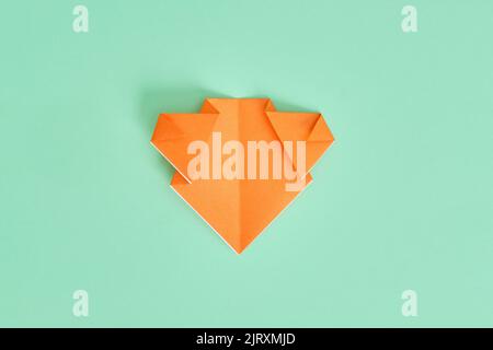 Origami-Bär. Schritt-für-Schritt-Fotoanleitung auf grünem Hintergrund. DIY-Konzept. Step7 Stockfoto