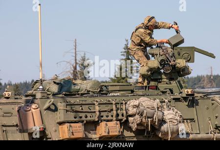 Ein Soldat von 3. Platoon, Blackhorse Company, 2-3 Infantry Regiment, 1-2 Stryker Brigade Combat Team lädt das montierte Maschinengewehr des Kalibers .50 auf sein gepanzertes Stryker Fahrzeug während einer Bewegung-zu-Kontakt-städtischen Razzia Übung auf der Joint Base Lewis-McChord, Washington, 24. August 2022. Die Übung war Teil einer zweitägigen Demonstrationsveranstaltung, die vom Program Executive Office of Ground Combat Systems veranstaltet wurde, mit dem Ziel, das Feedback der Soldaten in die Entwicklung neuer militärischer Kampftechnologien zu integrieren. (USA Armee-Foto von SPC. Chandler Coats, 5. Mobile Public Affairs Detachment) Stockfoto