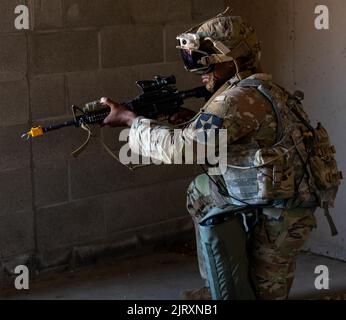 Ein Soldat von 3. Platoon, Blackhorse Company, 2-3 Infanterie-Regiment, 1-2 Stryker Brigade Combat Team trägt eine verbesserte integrierte visuelle Augmentation System-Brille, während er während einer Bewegung-zu-Kontakt-städtischen Razzia Übung auf der Joint Base Lewis-McChord, Washington, 24. August 2022 an Sicherheit zieht. Die Übung war Teil einer zweitägigen Demonstrationsveranstaltung, die vom Program Executive Office of Ground Combat Systems veranstaltet wurde, mit dem Ziel, das Feedback der Soldaten in die Entwicklung neuer militärischer Kampftechnologien zu integrieren. (USA Armee-Foto von SPC. Chandler Coats, 5. Mobile Public Affairs Detachment) Stockfoto