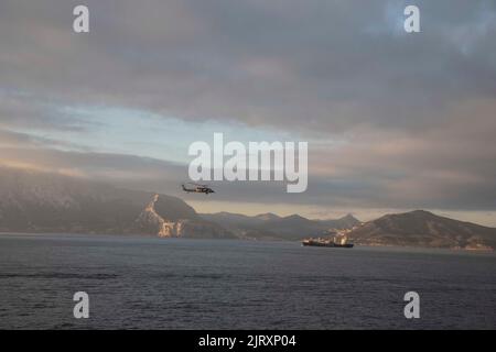 220825-N-ZG822-1074 STRASSE VON GIBRALTAR (AUG 25, 2022) ein MH-60s Nighthawk-Hubschrauber, der an das Helicopter Sea Combat (HSC) Squadron 5 angeschlossen ist, fliegt während des George H.W. über die Straße von Gibraltar Der Transit der Bush Carrier Strike Group (GHWBCSG) durch die Straße von Gibraltar ins Mittelmeer, 25. August 2022. Die GHWBCSG besteht aus dem Flugzeugträger USS George H.W. der Nimitz-Klasse Bush (CVN 77), Carrier Air Wing (CVW) 7, Destroyer Squadron (DESRON) 26, der Information Warfare Commander und der Ticonderoga-Klasse Lenkraketen-Kreuzer USS Leyte Gulf (CG 55). Das GHWBCSG befindet sich auf einem sc Stockfoto