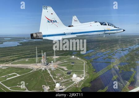 Florida, USA. 26. August 2022. Die NASA T-38s, eine Einrichtung des Astronautentrainings, fliegt am 25. August 2022 in Formation über der Space Launch System (SLS)-Rakete auf dem Launch Pad 39B im Kennedy Space Center, Cape Canaveral, Florida. Die Raumfahrzeuge SLS und Orion für die Artemis I-Mission starten spätestens am 29. August 2022. Astronaut Andrew Morgan postete dieses Foto auf Twitter und sagte: 'Diese Woche flogen wir über @NASAArtemis, dankten den @nasa-Zentren im ganzen Land, die diese Mondrakete auf @NASAKennedys Pad stellten und feierten den bevorstehenden Testflug!' NASA/UPI Credit: UPI/Alamy Live News Stockfoto