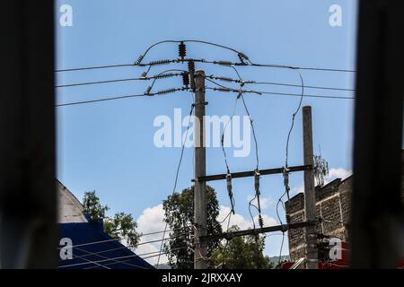 Nakuru, Rift Valley, Kenia. 26. August 2022. Betonmasten mit Stromkabeln auf der Kenyatta Lane in Nakuru Town. Die ugandische Regierung hat letzte Woche damit begonnen, Strom aus Kenia zu importieren, um einen Stromausfall zu schließen, nachdem Überschwemmungen eine Abschaltung von 183Megawatt am Isimba-Wasserkraftdamm verursacht hatten. Der im März in Betrieb genommene Staudamm wurde teilweise von der chinesischen Exim Bank finanziert. (Bild: © James Wakibia/SOPA Images via ZUMA Press Wire) Stockfoto