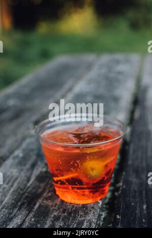 Aperol Spritz Aperitif-Cocktail in Plastikbecher auf Picknicktisch Stockfoto