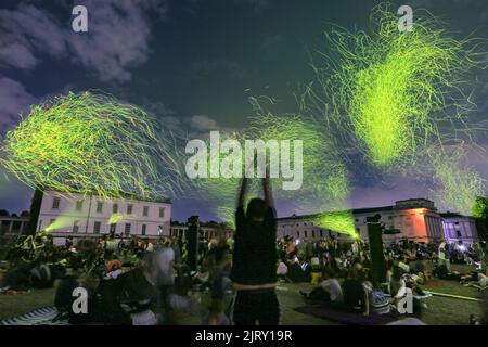 London, Großbritannien. 26. August 2022. Das organische Feuerwerk von Studio Roosegaarde beleuchtet Greenwich bei dieser nachhaltigen Feier und der spektakulären UK-Premiere im historischen Queen's House Gebäude, Greenwich. Die Menschen beobachten, wie sich Tausende biologisch abbaubarer Lichtfunken organisch mit dem Wind bewegen. SPARK ist eine der Hauptinstallationen beim diesjährigen Greenwich and Docklands International Festival. Kredit: Imageplotter/Alamy Live Nachrichten Stockfoto