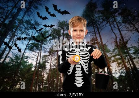 Junge mit Süßigkeiten und Taschenlampe an halloween Stockfoto