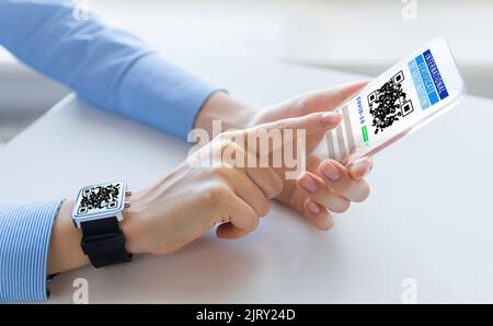 Hände mit virtuellem Immunitätspass auf dem Smartphone Stockfoto