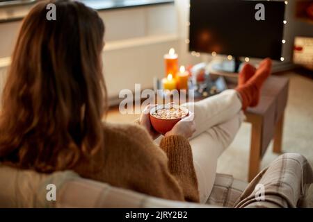 Frau schaut an halloween Fernsehen und trinkt Kakao Stockfoto