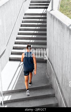 Junger Mann, der die Treppe rennt Stockfoto