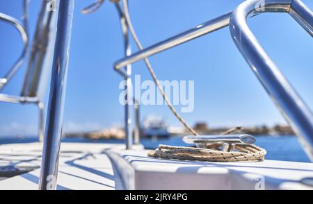 Detail eines Handlaufs und eines Seils, das an einem Haken auf einem Boot befestigt ist Stockfoto