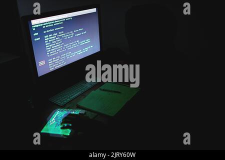 Tun Sie Ihr Bestes, um Ihre Daten zu schützen. Ein nicht identifizierbarer Hacker, der spät in der Nacht einen Computer benutzt. Stockfoto