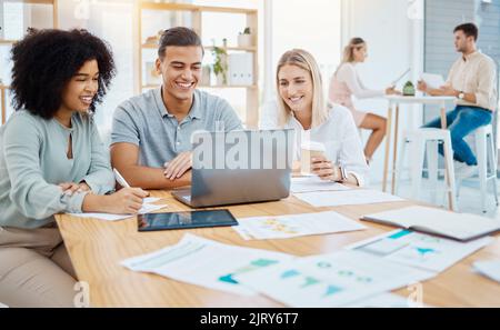 Glückliche Geschäftsleute, die in einem Unternehmensbüro an einem Laptop arbeiten und Ziele und Strategien lesen. Diverse Kollegen arbeiten an einem digitalen Online-Projekt zusammen Stockfoto