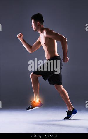 Sein Knöchel nimmt den ganzen Aufprall auf. Ganzkörperaufnahme eines jungen Mannes im Studio mit einem Cgi, der seine Knöchelverletzung hervorhebt. Stockfoto