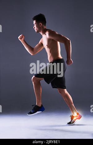 Nun, er wäre zu einem Flieger abgekommen. Ganzkörperaufnahme eines jungen Mannes im Studio mit einem Cgi, der seine Knöchelverletzung hervorhebt. Stockfoto