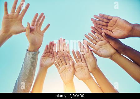 Befreien Sie sich. Eine vielfältige Gruppe von Menschen, die ihre Hände in die Luft heben. Stockfoto