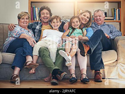 Quality Time stärkt das Band einer Familie. Porträt von drei Generationen von Familie, die sich zu Hause auf dem Sofa entspannen. Stockfoto