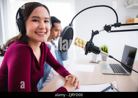 Junge asiatische Frau und Mann, die als dj und Podcast Aufnahmen und arbeiten und Heimstudio-Konzept ausstrahlten Stockfoto