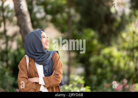 Porträt einer muslimischen Frau, die draußen zur Seite geht Stockfoto